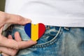 Patriot of the Romania! Wooden badge with Romania flag in the shape of a heart in a man`s hand on National Unity Day