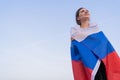 Patriot woman. A beautiful Russian woman with the flag of the Russian Federation looks to the future against the bright Royalty Free Stock Photo