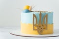 Patriotic cake with yellow and blue cream cheese frosting decorated with the state coat of arms of Ukraine. Independence Day Cake. Royalty Free Stock Photo