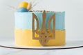 Patriotic cake with yellow and blue cream cheese frosting decorated with the state coat of arms of Ukraine Royalty Free Stock Photo