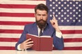 Patriotic concept. American lawyer teacher or tv host hold book american flag background. Love homeland. Man with beard Royalty Free Stock Photo