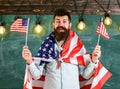Patriotic education concept. Student exchange program. American teacher waves with american flags. Man with beard and
