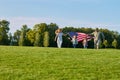 Patriotic family with huge usa flags outdoors. Royalty Free Stock Photo