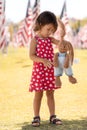 Patriotic holiday child with bunny toy in the park and American flags at Memorial Day Royalty Free Stock Photo