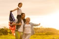 Patriotic holiday. Happy family, parents and daughters children girl with American flag outdoors. USA celebrate 4th of Royalty Free Stock Photo