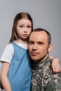 patriotic kid hugging serviceman in army