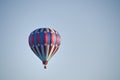 Patriotic red white and blue hot-air balloon taking off into the blue morning sky Royalty Free Stock Photo