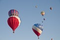Patriotic red white and blue hot-air balloon taking off with many other hot air balloons into the blue morning sky Royalty Free Stock Photo
