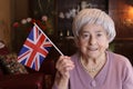 Patriotic senior woman waving the beautiful Great Britain national flag Royalty Free Stock Photo