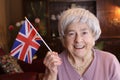 Patriotic senior woman waving the beautiful Great Britain national flag Royalty Free Stock Photo