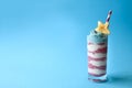 Patriotic smoothie glasses with blue spirulina, strawberry and vanilla smoothies on blue background