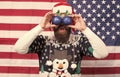 Patriotic surprise. Surprised hipster hold baubles as glasses. Bearded man look with surprise. Santas surprise