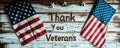 Patriotic tribute to military service members with a Thank You Veterans message on a white wooden background, adorned by an
