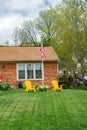 Patriotic yard at home. Neat lawn with American flag and chairs. Decoration for independence day