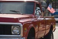 Patriotism: Old red American Pickup truck with flag at the rear end Royalty Free Stock Photo