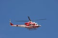 Patrol helicopter of firefighters in blue sky over a fire