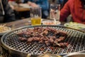 patrons seated at a korean bbq with meat on the grill Royalty Free Stock Photo