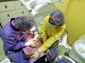 Doctor in uniform checking up Dentist examining kid`s teeth at dental clinic