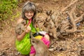 Monkeys surrounded a happy tourist who feeds them with fruit