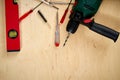 Pattern background of various screwdrivers and a drill with a spirit level on wooden work table