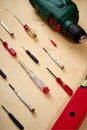 Pattern background of various screwdrivers and a drill with a spirit level on a wooden work table