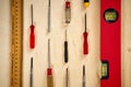 Pattern background of various screwdrivers with a spirit level and measuring tape on wooden work table