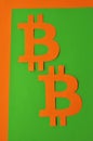 The pattern of bitcoin signs on a green background in an orange frame is vertical orientation. Conceptual collage about Royalty Free Stock Photo