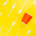 Pattern of broken plastic forks, and plastic cup on a yellow background. Royalty Free Stock Photo