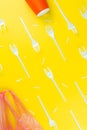 Pattern of broken plastic forks, plastic cup and bag on a yellow background. Royalty Free Stock Photo