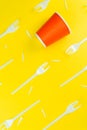 Pattern of broken plastic forks, and plastic cup on a yellow background. Royalty Free Stock Photo