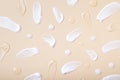 Pattern of brush strokes and drops of cosmetic oil and serum top view on beige background