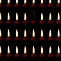 Pattern of burning candles with one extinguished candle from which rises a plume of smoke Royalty Free Stock Photo