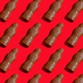 Pattern chocolate Santa Claus on a red background. Sweet Christmas candy. Sweet food for the holiday. Treat Royalty Free Stock Photo