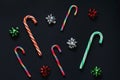 Pattern of Christmas candy cane and bows for gifts green, red and silver colors. New Year decorations  Black background, top view Royalty Free Stock Photo