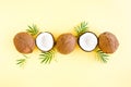 Pattern with coconuts and tropical palm leaves on yellow background. Tropical abstract background. Flat lay, top view. Royalty Free Stock Photo