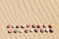 Pattern of colored pebbles on clean sand. Zen background, harmony and meditation concept Royalty Free Stock Photo