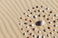 Pattern of colored pebbles in the shape of a circle on clean sand Royalty Free Stock Photo