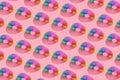 Pattern of colorful plastic spring toys on pink background.