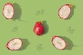 Pattern created from fresh exotic dragon fruit as whole, half and seeds on pastel green background. Top view Royalty Free Stock Photo