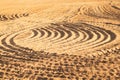 Pattern of curved ridges and furrows on a sandy field. traces on the sand