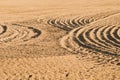 Pattern of curved ridges and furrows on a sandy field. traces on the sand