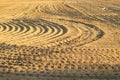 Pattern of curved ridges and furrows on a sandy field. traces on the sand Royalty Free Stock Photo