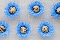 Pattern of decorated quail eggs in the form of blue flowers on a background of natural linen fabric. Children`s creativity, craft