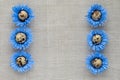 Pattern of decorated quail eggs in the form of blue flowers on a background of natural linen fabric. Children`s creativity, craft