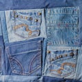 A pattern of denim pockets on a blue background for jeans sewn from pieces of fabric Royalty Free Stock Photo