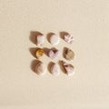 Pattern with different pebble sea stones and one stone heart on fine sand. Square composition from natural rocks neutral Royalty Free Stock Photo