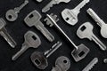 A pattern of different types of keys from locks laid out on black surface top view Royalty Free Stock Photo