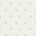 Pattern featuring scattered simplistic bird footprints in a light gray color on an off-wh Royalty Free Stock Photo