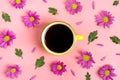 Pattern of flowers of pink asters, green leaves and yellow cup of hot coffee Americano on pink background Flat lay Royalty Free Stock Photo