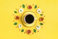 Pattern of flowers of red and white asters, green leaves and a cup of hot coffee on yellow background Royalty Free Stock Photo